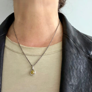 Karen Karch Inner Circle Silver Charm with Yellow Diamond Rose Cut Charm Pendant on neck.