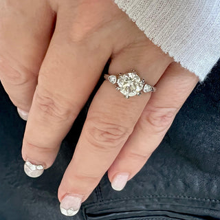 Karen Karch Invincible Crown Platinum Old European Diamond Ring with small side stones on a hand.