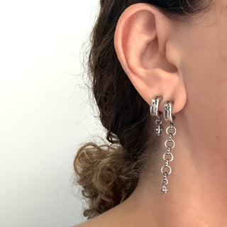 Mainstay Silver mismatched hoop earrings, one with a chain and drop and the other with a drop together on an ear.