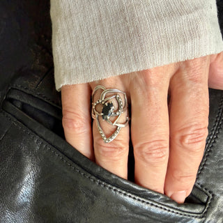 Karen Karch Silver Rose Tattoo Outline Ring with ball details and a dark blue sapphire center stone held by 4 claws on a hand.