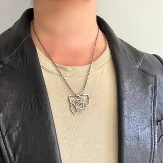 Karen Karch Silver Rose Tattoo Slide pendant with a central emerald bezel-set stone on chain on a person.