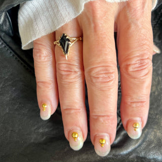 Karen Karch by Deme Wolfe diamond-shaped black onyx gemstone set in a chiseled 14k yellow gold band ring on a hand