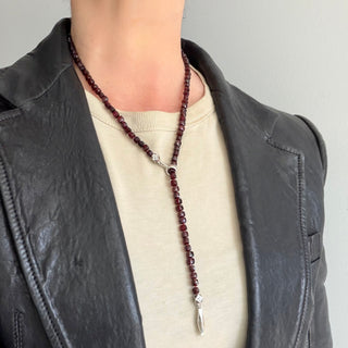 Karen Karch Garnet Faceted Square Bead Necklace with weathered silver Bar and pull through clasp on the neck of a person wearing a t-shirt and leather  jacket.