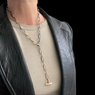 A Karen Karch Silver and Gold Textured Toggle Chain Necklace designed to be worn in a lariat shape shown on the neck.