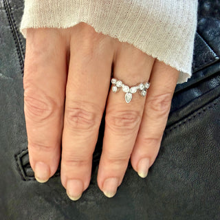 Karen Karch Platinum Bezel-set Diamond Curved Belgian Tiara Ring with 8 round diamonds configured in the shape of a tiata with a pear shape diamond set in the top center on a hand.