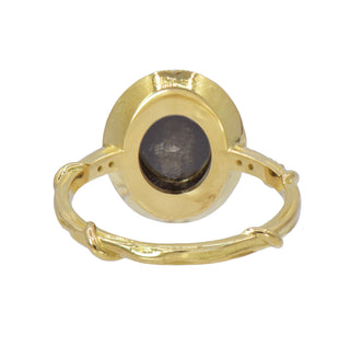 Back view of a Karen Karch 18k Yellow Gold Dark Grey Oval Diamond ring surrounded by a order of black and white diamonds. There are 3 diamonds each side of center on the band.  