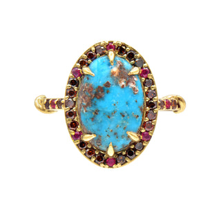 a gold Karen Karch Regal Ring with matrix turquoise oval stone with a halo of small cognac diamonds and rubies on a white background.