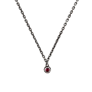 Karen Karch Silver Charm Necklace with a small round red ruby gemstone pendant on a thin chain against a white background