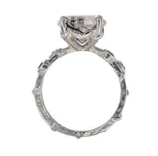 Top view of a Karen Karch ring with two textured sterling silver bands intertwine with delicate vine details and four bezel-set black diamonds flanking an 11mm round center rutilated quartz in a claw setting.