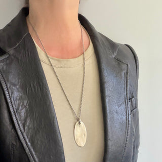 Karen Karch Weathered Silver Legend Oval Dog Tag with Round Textured Bail on a person.