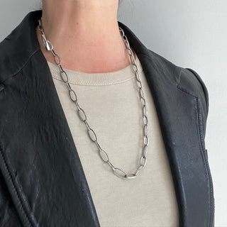 A Karen Karch Sterling Silver Textured Toggle Oval Chain Link Necklace worn in an oval shape