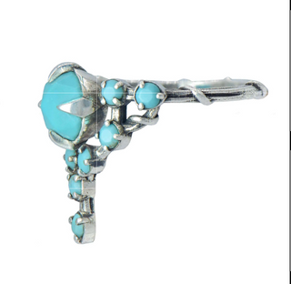 A Karen Karch silver cocktail ring featuring a large round turquoise center stone surrounded by smaller turquoise stones, in a star-like formation, side view on a white background.