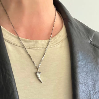 KAREN KARCH Silver Unearthed Textured Lucky Horn on chain on person in leather jacket.