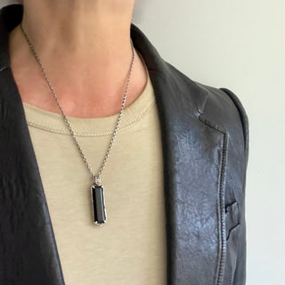 Back side of Karen Karch Silver Vine Entwined Elongated merald Cut Onyx Amulet on a neck.