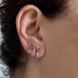 Karen Karch Pair of Sterling Silver Vine Tattoo Weathered curved Bar earrings paired together on one ear.