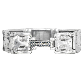 A 20mm wide weathered silver bracelet with a studded clasp featuring black and white diamonds, designed by Karen Karch.