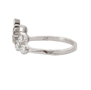 Side view of a Karen Karch Platinum Bezel-set Diamond Curved Belgian Tiara Ring with 8 round diamonds configured in the shape of a tiata with a pear shape diamond set in the top center on a white background. 