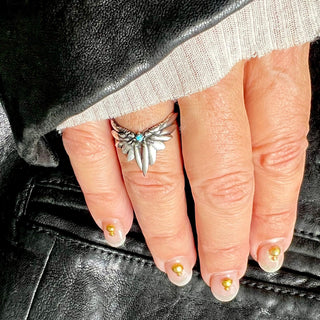 Karen Karch by Deme Wolfe sterling silver ring featuring a tiara-like design with two wings and a central turquoise stone on a hand.