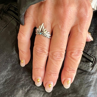 Karen Karch by Deme Wolfe sterling silver ring featuring a tiara-like design with two wings and a central turquoise stone on a hand.