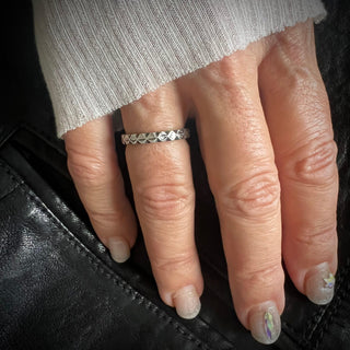 Karen Karch Outshine Weathered 3mm silver band with a textured, angular repeating pattern design on hand.