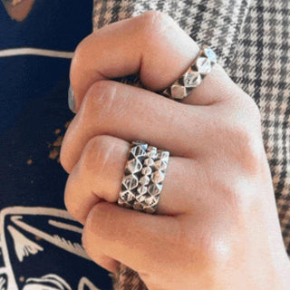 Karen Karch Outshine Weathered silver bands on hand, all widths stacked with a textured, angular repeating pattern design.