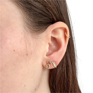 Karen Karch by Deme Wolfe Snake Stud Earrings in 10k yellow gold on the ear styed with Wing Stud