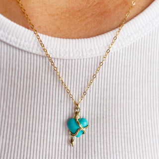 Karen Karch by Deme Wolfe Serpentine Love Turquoise Heart embraced by a 10k yellow gold snake on a gold filled chain on a person in white t shirt