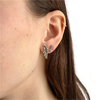 Karen Karch by Deme Wolfe pair of silver-colored earrings designed with a detailed wing motif, on the ear in 2 sizes