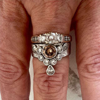 Close-up of a hand wearing a "before" Ring stacked with a Karen Karch Natural Brown Diamond Floating Star Platinum Ring.