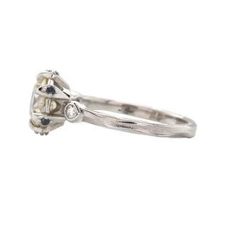 Karen Karch Invincible Crown Platinum Old European Diamond Ring with a black diamond in each claw and small side stones, side view, on white background.