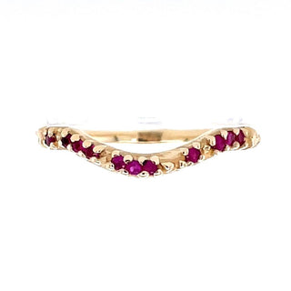 A Karen Karch by Deme Wolfe 14k yellow gold ring with rubies on the front of a curved band on a white background. 