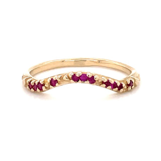 A Karen Karch by Deme Wolfe 14k yellow gold ring with rubies on the front of a curved band on a white background. 