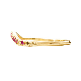 A Karen Karch by Deme Wolfe 14k yellow gold ring with rubies on the front of a curved band, full side view,  on a white background. 