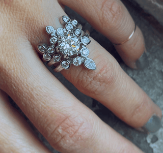Karen Karch Turned Out Belgian Tiara Curved Ring in 18ky with 10 brilliant cut colorless diamonds in a crown like formation stacked with 2 other diamond rings on a hand.